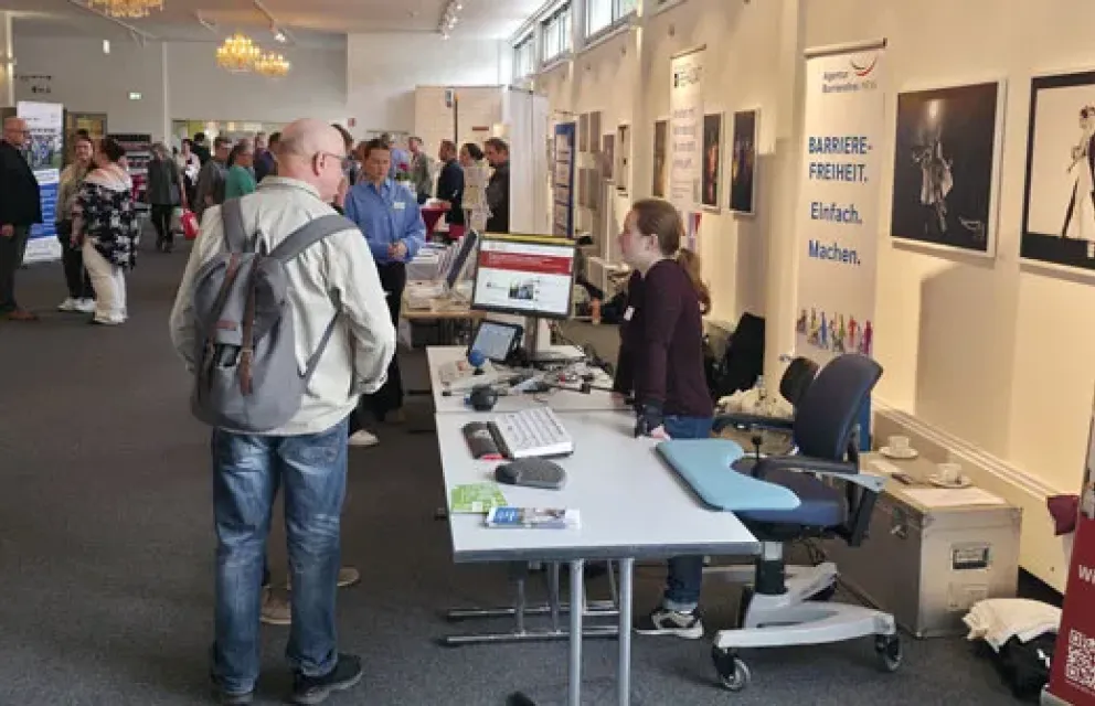KBV-Mitarbeiterin Hanja Lauman berät am Stand der Agentur Barrierefrei NRW
