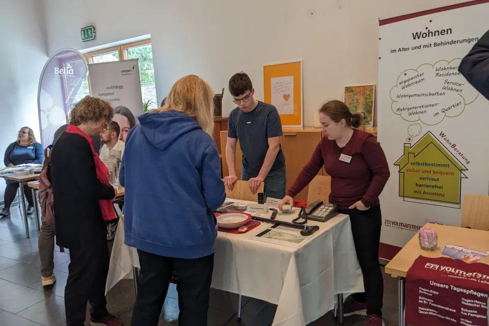 Die Wohnberaterin Hanja Laumann informiert am Infostand unterstützt vom Praktikanten Philipp Dinger über Hilfsmittel, die den Alltag erleichtern.