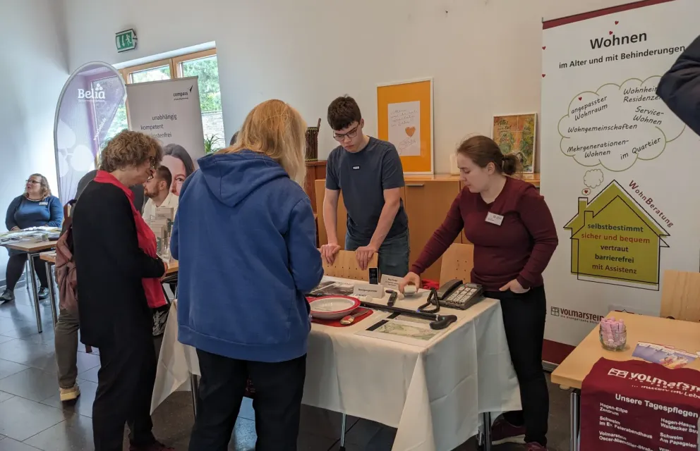 Die Wohnberaterin Hanja Laumann informiert am Infostand unterstützt vom Praktikanten Philipp Dinger über Hilfsmittel, die den Alltag erleichtern.