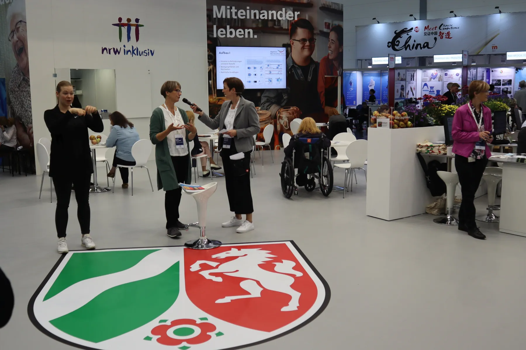 Vorstellung der Baubroschüre durch Lydia Weyandt am NRW inklusiv Stand mit Gebärdensprachdolmetschung mit Link zur vergrößerten Ansicht