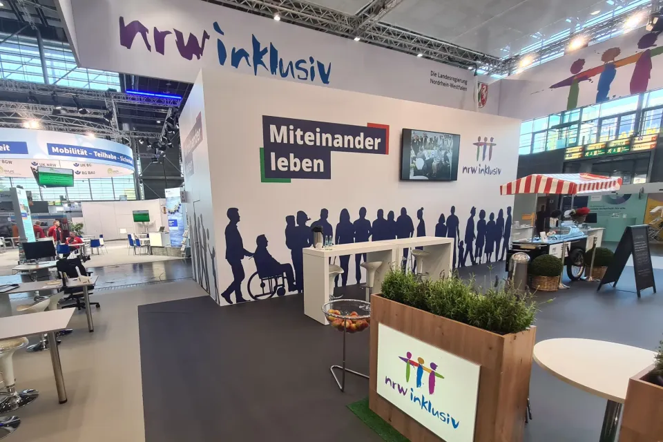Foto des noch leeren Messestands der Landesregierung NRW mit dem Schriftzug nrw inklusiv, Miteinander leben.