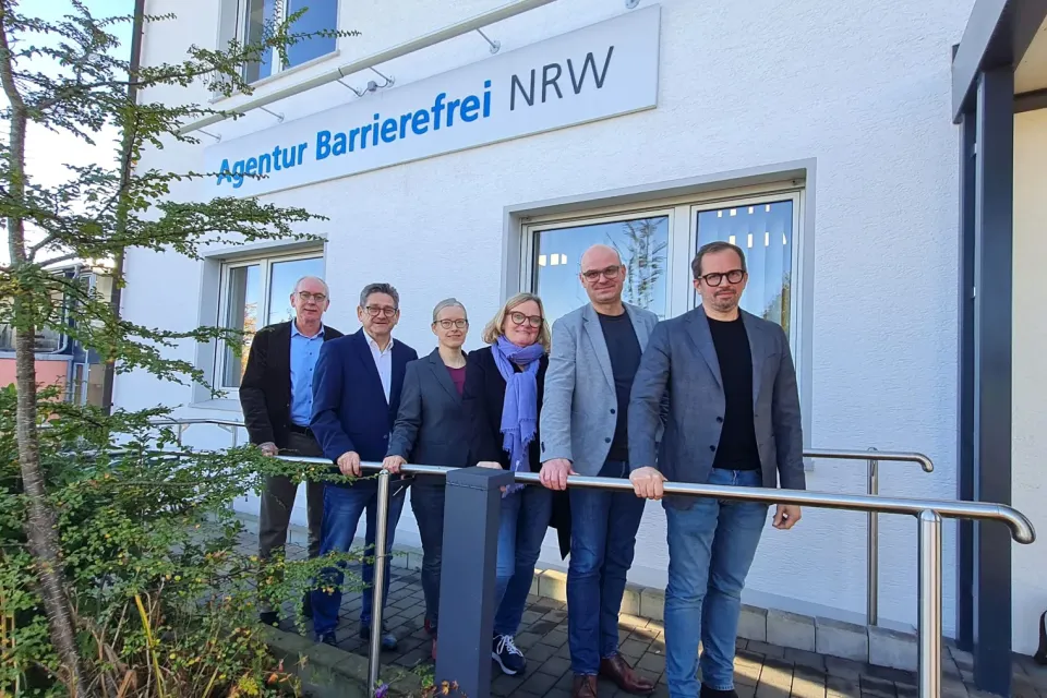 Sechs Personen stehen nebeneinander vor dem Gebäude der Agentur Barrierefrei NRW: (v.li.) Wolfgang Schmitz (Leiter Kompetenzzentrum Barrierefreiheit Volmarstein), MdL Josef Neumann, Annika Nietzio (stellv. Leiterin Kompetenzzentrum Barrierefreiheit Volmarstein), MdL Kirsten Stich, Dirk Domann (Geschäftsbereichsleiter Ev. Stiftung Volmarstein) und Markus Bachmann (Vorstand Ev. Stiftung Volmarstein)