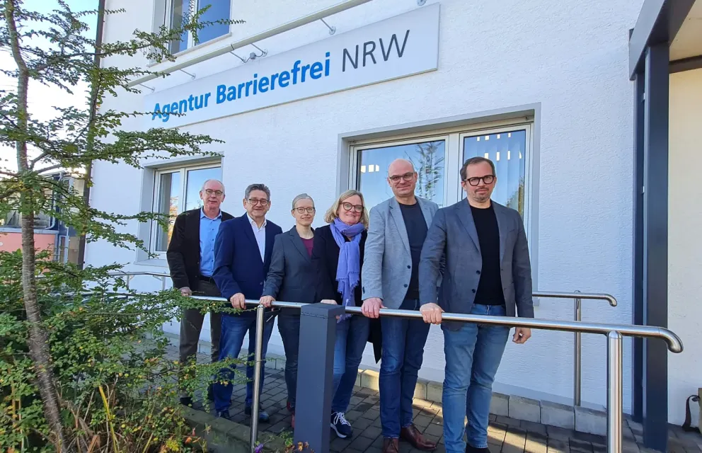 Sechs Personen stehen nebeneinander vor dem Gebäude der Agentur Barrierefrei NRW: (v.li.) Wolfgang Schmitz (Leiter Kompetenzzentrum Barrierefreiheit Volmarstein), MdL Josef Neumann, Annika Nietzio (stellv. Leiterin Kompetenzzentrum Barrierefreiheit Volmarstein), MdL Kirsten Stich, Dirk Domann (Geschäftsbereichsleiter Ev. Stiftung Volmarstein) und Markus Bachmann (Vorstand Ev. Stiftung Volmarstein)